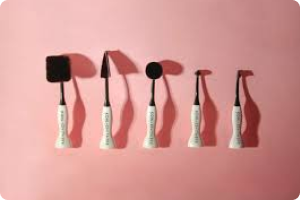 brush set with white handles on a pink background, brushes have black bristles